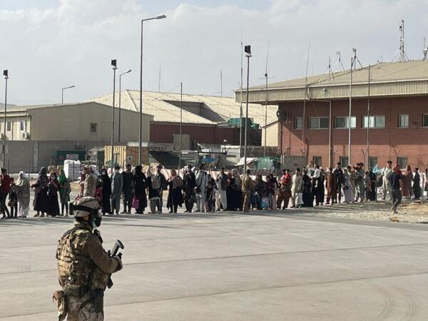 Afghan evacuees queue before boarding one of the last of Italy's military aircraft C130J during evacuation at Kabul's airport, Afghanistan, on Aug. 27, 2021. (Italian Ministry of Defence/Handout via Reuters)