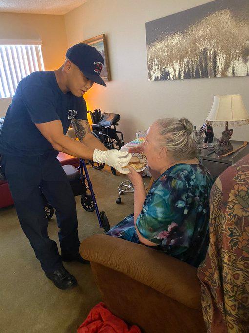 A firefighter feeds an elderly woman who had fallen. (Courtesy of the Orange County Fire Authority)