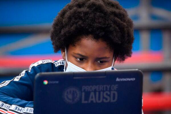 A child wears a face mask as they attend an online class at a learning hub inside the Crenshaw Family YMCA during the COVID-19 pandemic in Los Angeles, California, on Feb. 17, 2021. (Patrick T. Fallon/AFP via Getty Images)