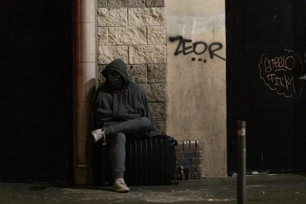 A man sits in Skid Row in Los Angeles, Calif., on Dec. 30, 2020. (John Fredricks/The Epoch Times)