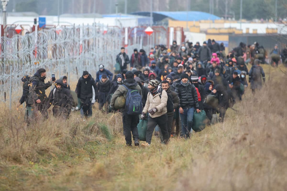 A group of migrants moves along the Belarusian-Polish border toward a camp to join those gathered at the spot and aiming to enter European Union member Poland, in the Grodno region of Belarus, on Nov. 12, 2021. (Leonid Shcheglov/Belta/AFP via Getty Images)