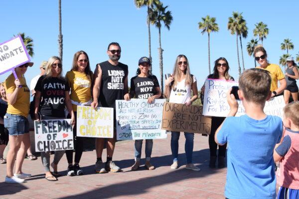 Parents and children gather at the San Clemente Pier for a statewide "Sit and Rally" demonstration to protest California's COVID-19 vaccine requirements for K–12 students in San Clemente, Calif., on Nov. 15, 2021. (Brandon Drey/The Epoch Times)