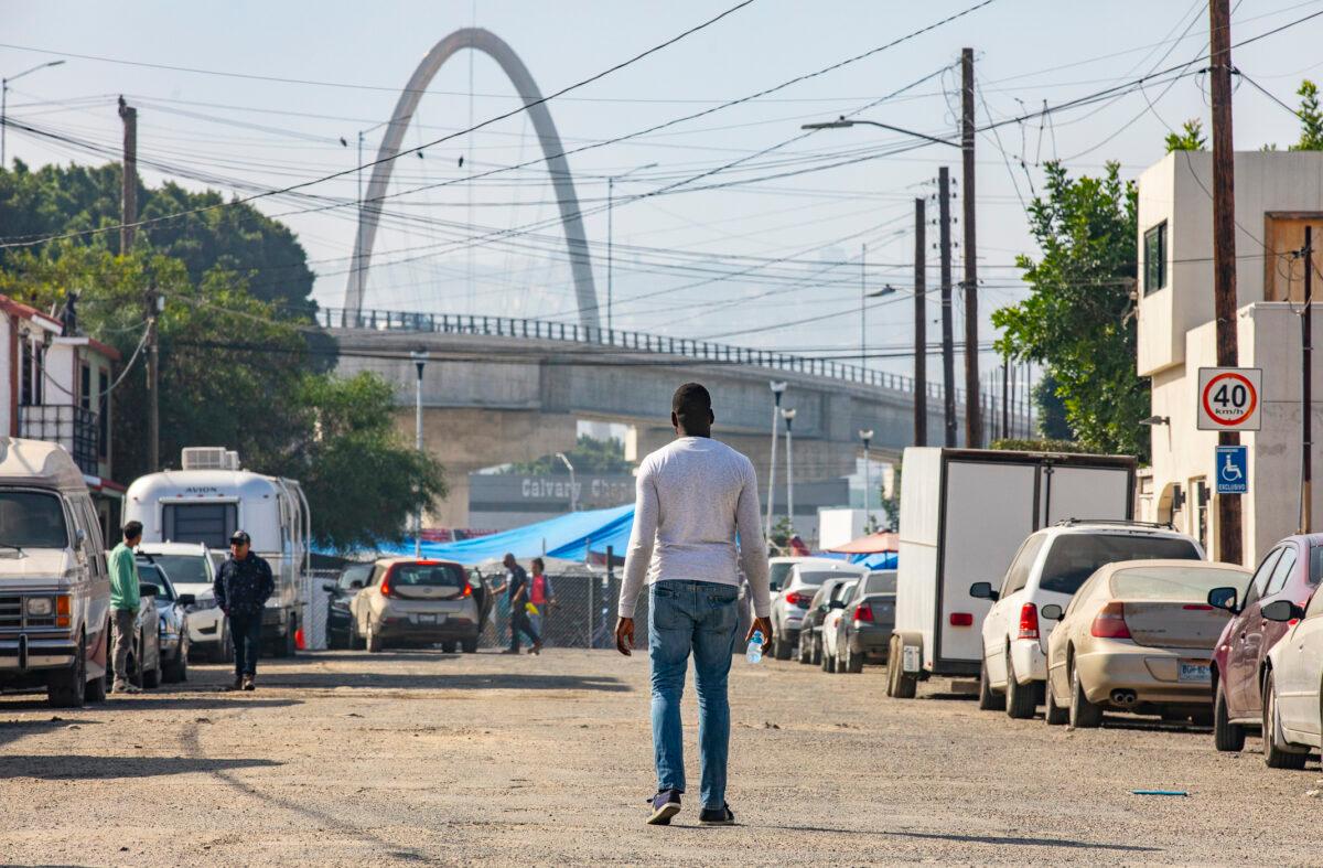 Elisé, a Haitian migrant living in Tijuana, Mexico, walks toward a migrant encampment near the U.S.-Mexican border on Nov. 6, 2021. (John Fredricks/The Epoch Times)