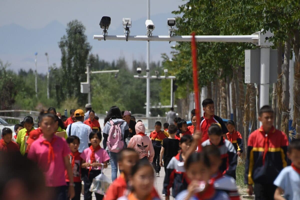 Schoolchildren walk under surveillance cameras in Akto, south of Kashgar, in China's western Xinjiang region on June 4, 2019. (Greg Baker/AFP via Getty Images)