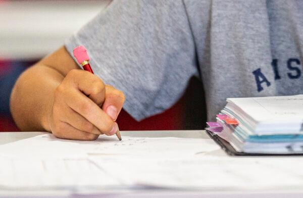 Elementary aged students work on their math homework in Laguna Niguel, Calif., on May 12, 2021. (John Fredricks/The Epoch Times)