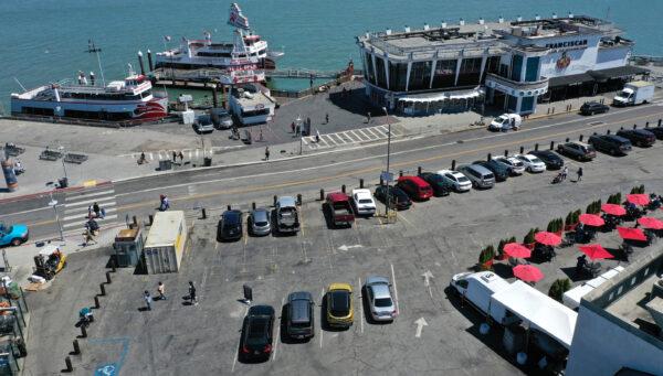 In an aerial view, cars and tables fill a parking lot next to a restaurant and bay cruise terminal at San Francisco's Fisherman's Wharf tourist destination on June 14, 2021. (Justin Sullivan/Getty Images)