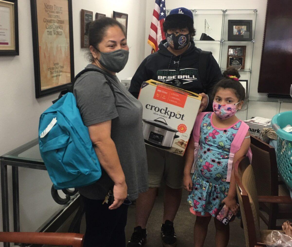 A family receives assistance from the Costa Mesa-based organization Serving People in Need. (Courtesy of Serving People in Need)