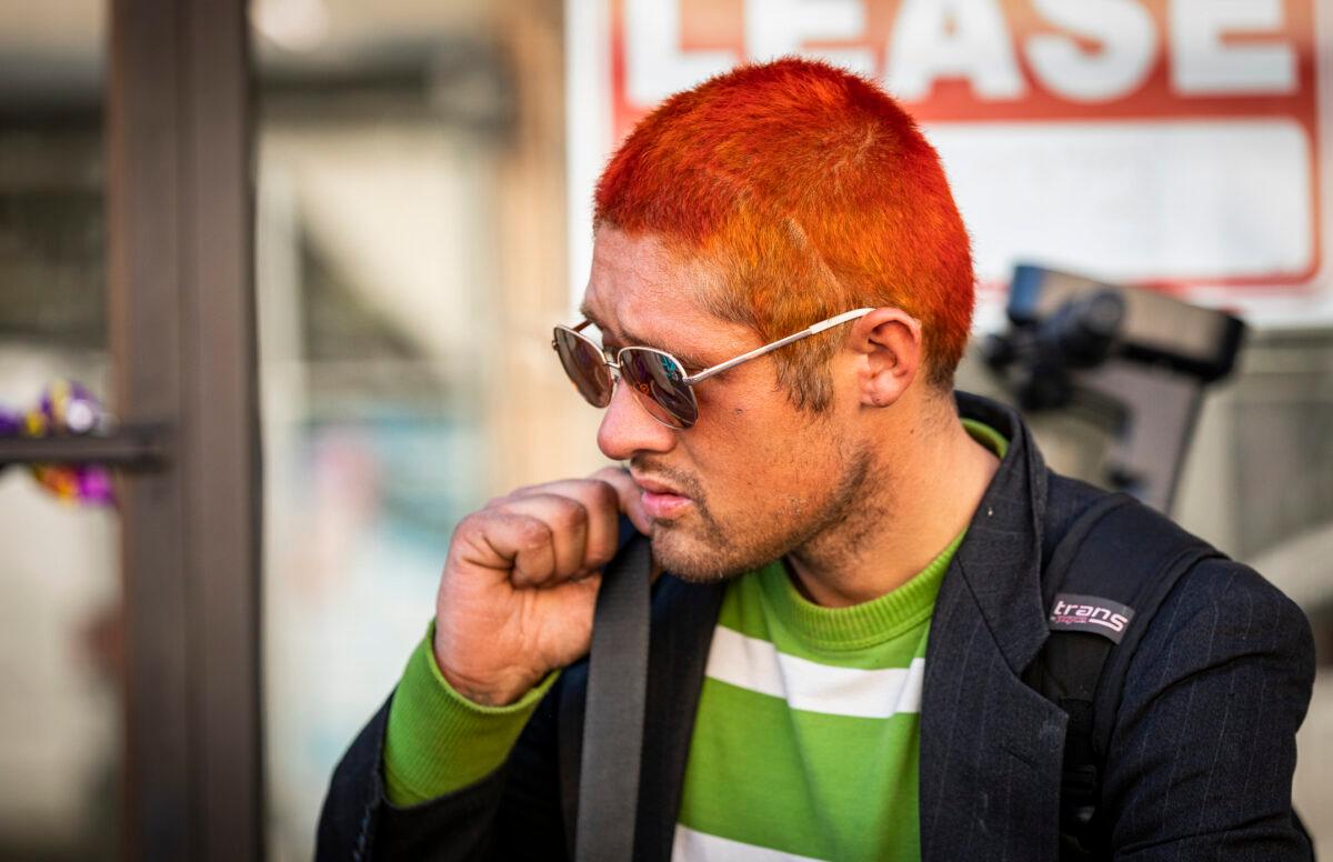 Austin, a homeless man from Boston, stands near his bicycle in downtown Los Angeles on Jan. 6, 2022. (John Fredricks/The Epoch Times)