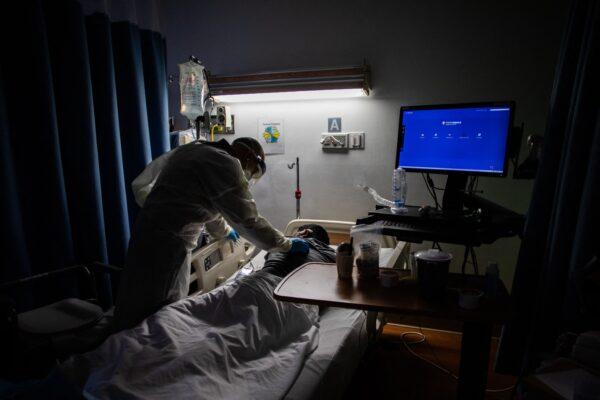 A doctor checks on a COVID-19 patient in a hospital in Los Angeles County, Calif., in a file photograph. (Apu Gomes/AFP via Getty Images)