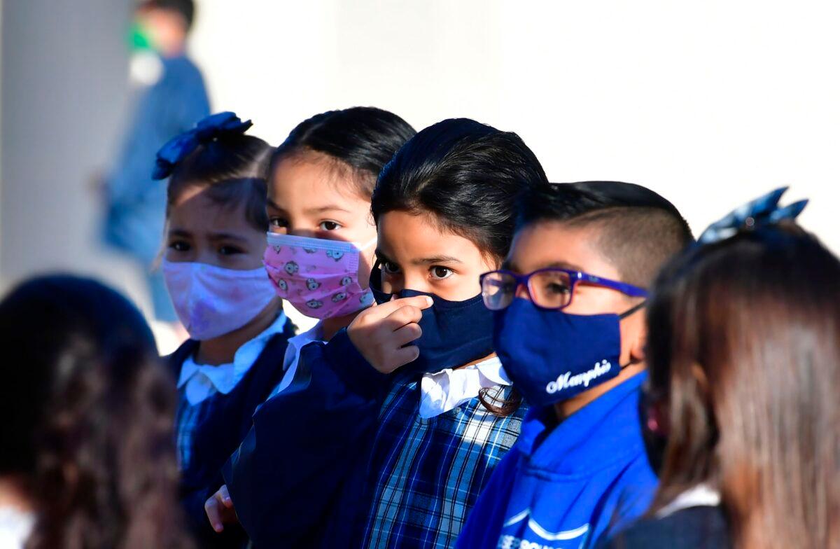 A students adjusts her facemask at St. Joseph Catholic School in La Puente, California, on Nov. 16, 2020. (Frederic J. Brown/AFP via Getty Images)