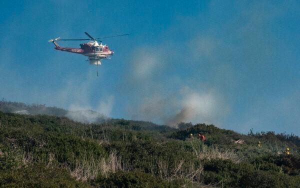 First responders work together in extinguising the flames of a wildfire buring in Laguna Beach, Calif., on Feb. 10, 2022. (John Fredricks/The Epoch Times)