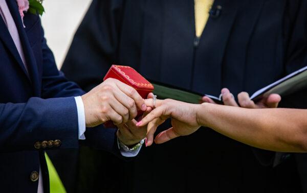 A man places a wedding ring on his bride's finger at Old Orange County Courthouse in Santa Ana, Calif., on Feb. 22, 2022.