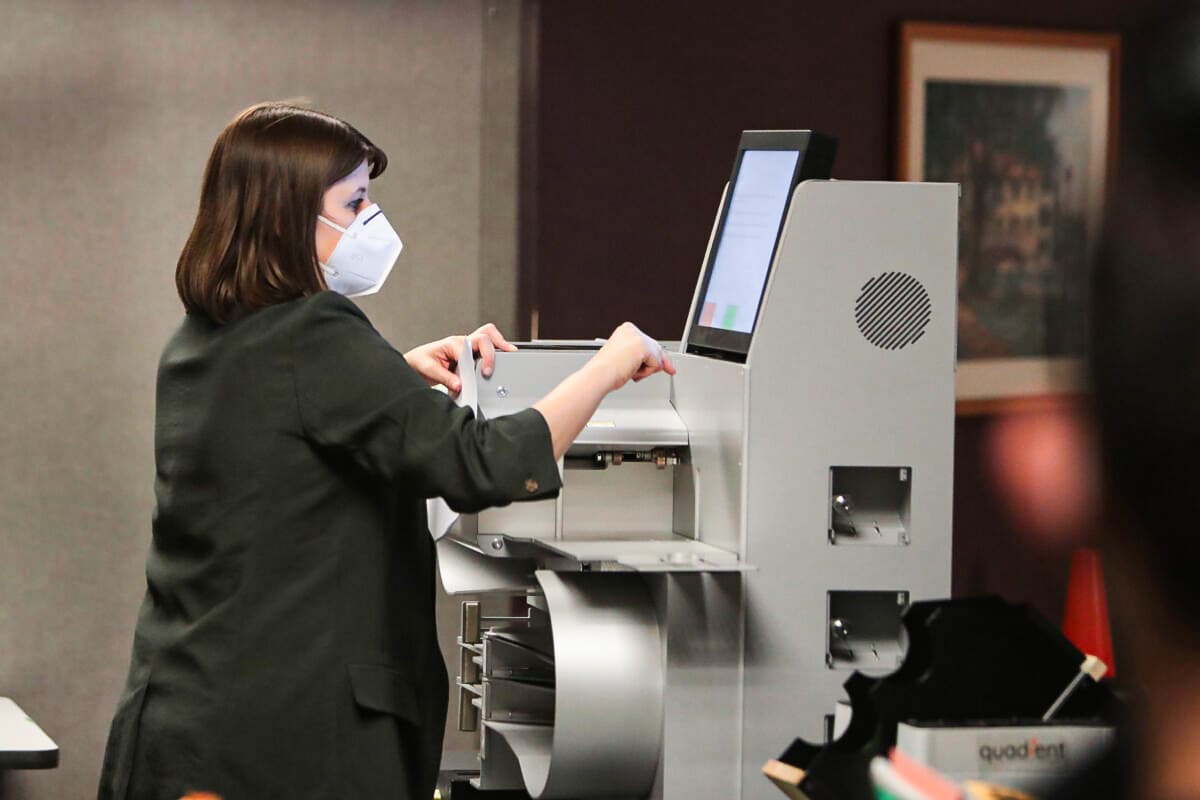 An election official collects data from absentee ballots from a voting machine in Milwaukee on Nov. 4, 2020. (Scott Olson/Getty Images)