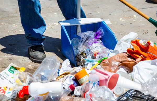 Los Angeles sanitation workers clean up trash left in Venice Beach, Calif., on June 8, 2021. (John Fredricks/The Epoch Times)