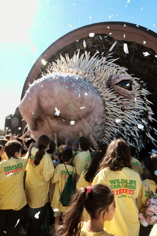 Los Angeles school children reach out to touch a giant puppet porcupine named Percy at Elysian Park in Los Angeles on March 1, 2022. (Richard Vogel/AP Photo)