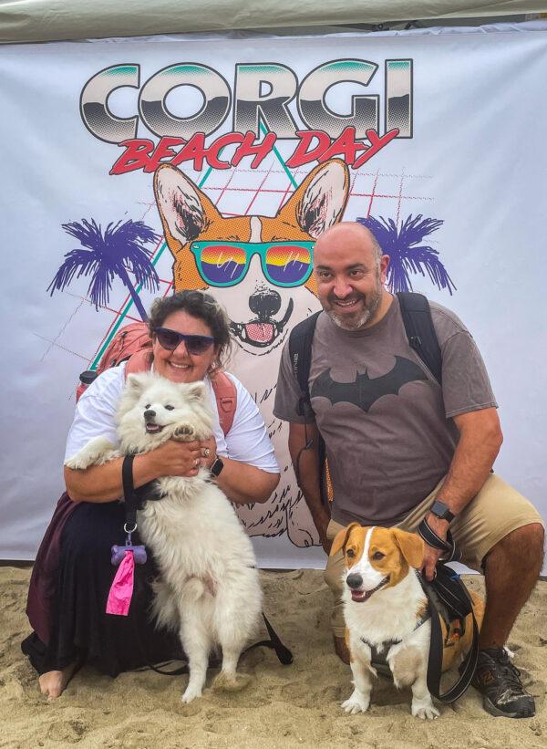 Krista and Paul, of Long Beach, pose with their corgis, Bernard and Hans, at the 10th Annual Corgi Beach Day in Huntington Beach on April 2, 2022. (Carol Cassis/The Epoch Times)