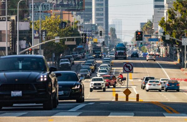 Cars and pedestrians travel in western Los Angeles on Nov. 10, 2021. (John Fredricks/The Epoch Times)