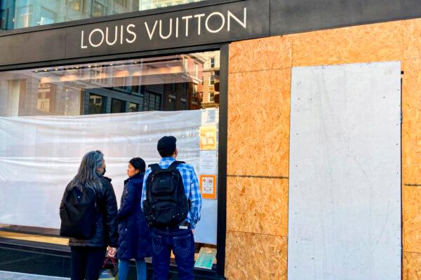 Union Square visitors look at damage to a Louis Vuitton store in San Francisco, Calif., on Nov. 21, 2021. (Danielle Echeverria/San Francisco Chronicle via AP)
