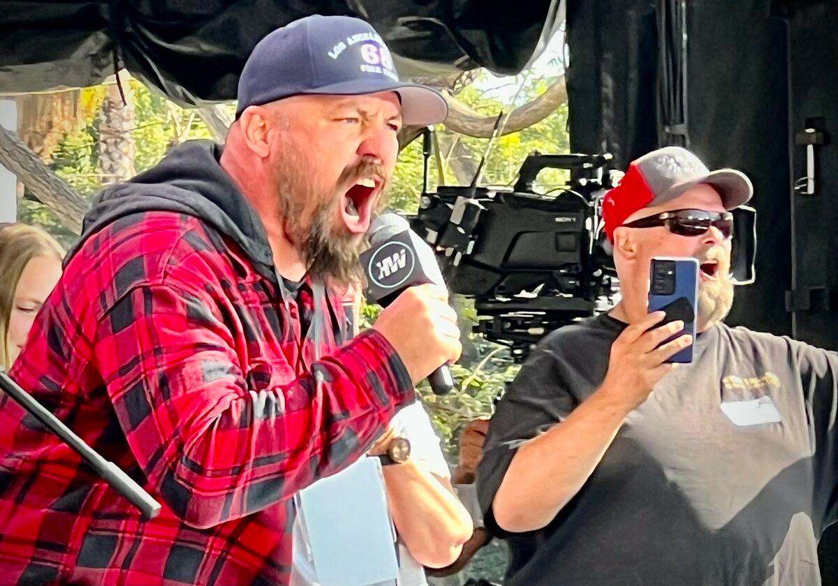 Brian Brase (L), a trucker and co-organizer of The People’s Convoy, speaks at the “Defeat the Mandates” rally in Los Angeles on April 10, 2022. (Brad Jones/The Epoch Times)