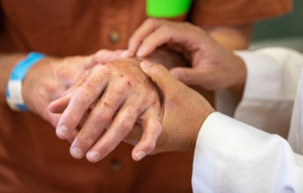 Burn victim Michael Zimmer's hands are checked by Dr. Theresa L. Chin at UCI Medical Center in Orange, Calif., on April 13, 2022. (John Fredricks/The Epoch Times)