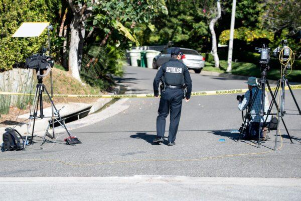 A police officer crosses under police tape near the 1100 block of Maytor Place, where Jacqueline Avant's house is, in Beverly Hills, Calif., on Dec. 1, 2021. (Valerie Macon/AFP via Getty Images)