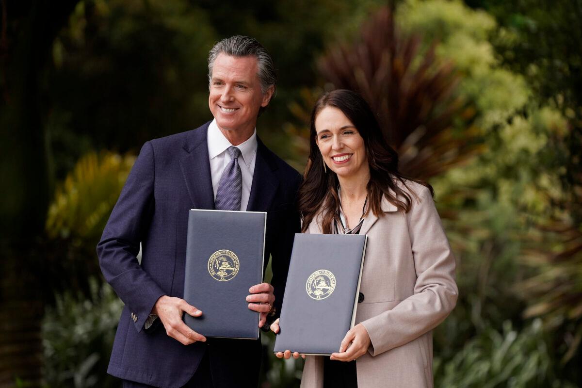 California Gov. Gavin Newsom and New Zealand Prime Minister Jacinda Ardern pose with signed agreements at an event in San Francisco, Calif., on May 27, 2022. (Eric Risberg/AP Photo)