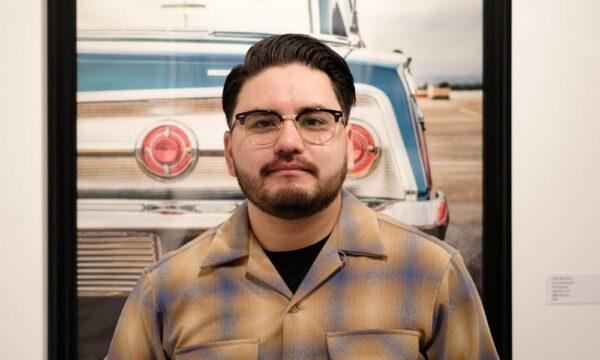 Santa Ana photographer Aaron Moctezuma stands in front of his work featured in the “Made in California” art exhibit at Brea Art Gallery in Brea, Calif., on April 30, 2022. (Courtesy of Omar Moncada)