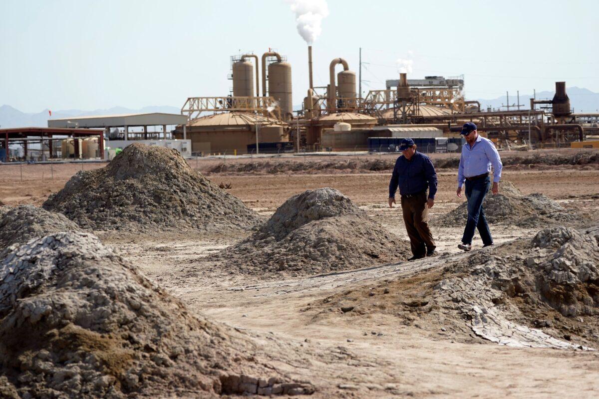 Two men walk along geothermal mud pots near the shore of the Salton Sea, where the company Controlled Thermal Resources is mining for lithium, in Niland, Calif., on July 15, 2021. (Marcio Jose Sanchez/AP Photo)