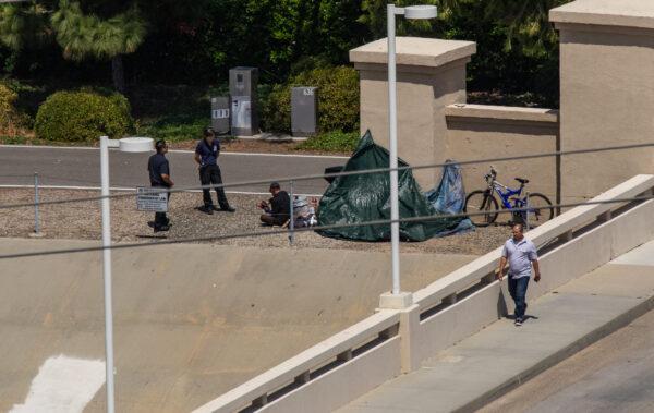 Be Well staff members assist two homeless individuals in Irvine, Calif., on June 8, 2022. (John Fredricks/The Epoch Times)