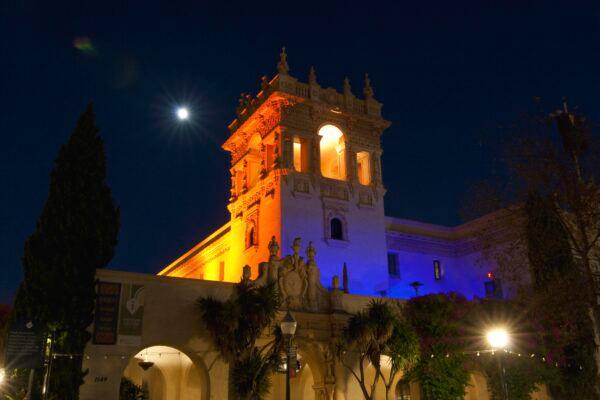 The beautifully lit tower of the Casa de Balboa overlooks the Plaza de Panama on a moonlit Balboa Park night. (Jeff Perkin for American Essence)