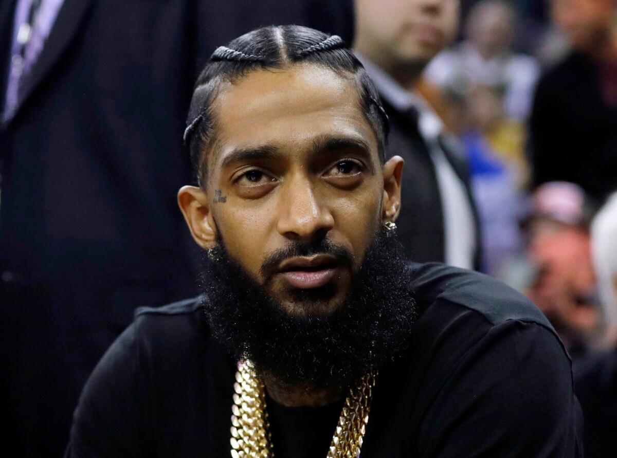 Rapper Nipsey Hussle attends an NBA basketball game between the Golden State Warriors and the Milwaukee Bucks in Oakland, Calif., on March 29, 2018. (Marcio Jose Sanchez/AP Photo)