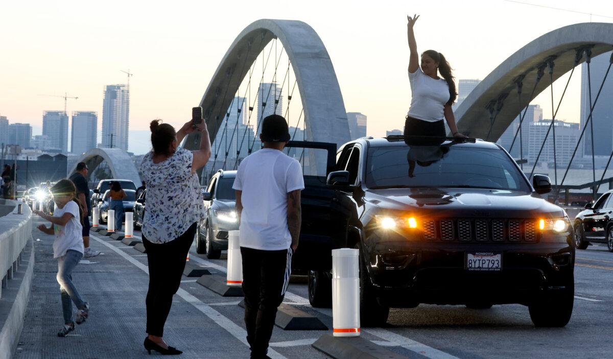 A person poses for a photo on the newly-opened 6th Street Viaduct, connecting Boyle Heights with downtown L.A., in Los Angeles on July 11, 2022. (Mario Tama/Getty Images)