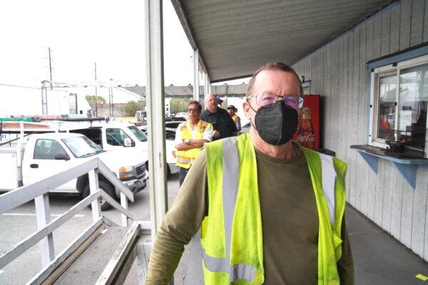 Michael Clifford, a company truck driver from Utah, waits in line for his entry papers at a transportation logistics company in Long Beach, Calif., on July 26, 2022. Clifford said he thinks California's new state labor law redefining owner-operators as employees will hurt the industry in the long term. (Allan Stein/The Epoch Times)