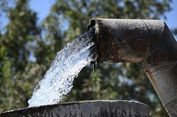 Water pumped up from an underground well flows into a cistern on a farm in Fresno, Calif., on July 24, 2021. (Robyn Beck/AFP via Getty Images)