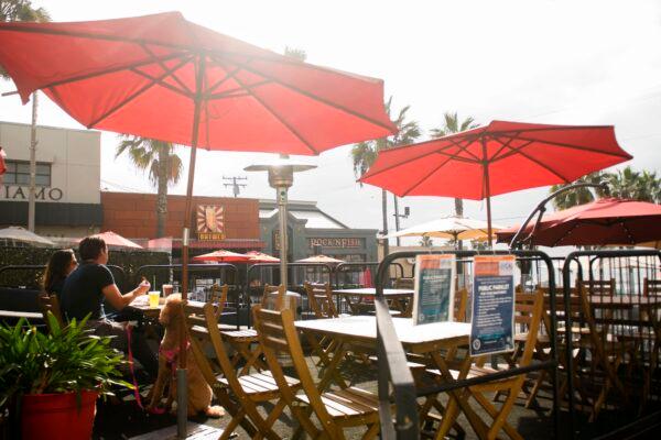 People eat take-out food outdoors at a "public parklet" due to COVID-19 restrictions on restaurant outdoor dining in Manhattan Beach, Calif., on Dec. 12, 2020. (Patrick T. Fallon/AFP via Getty Images)