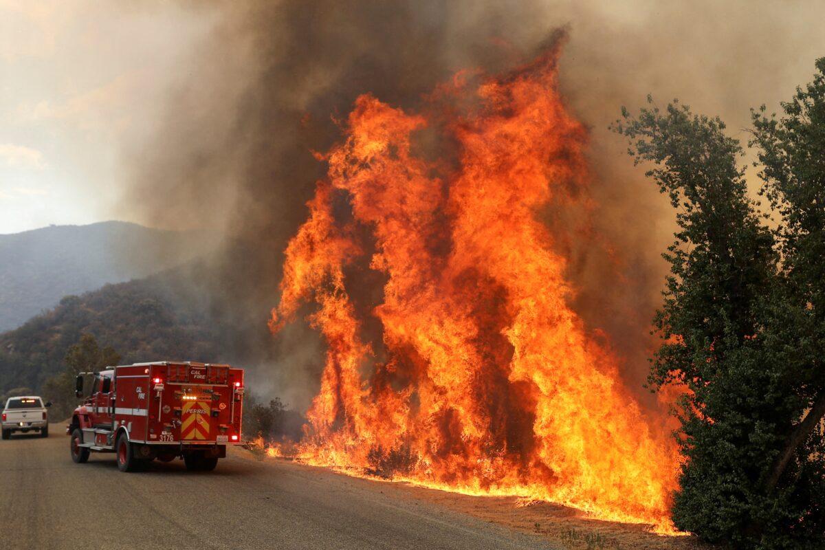 Flames grow next to a fire engine as the Fairview Fire burns near Hemet, Calif. on Sept. 7, 2022. (David Swanson/Reuters)
