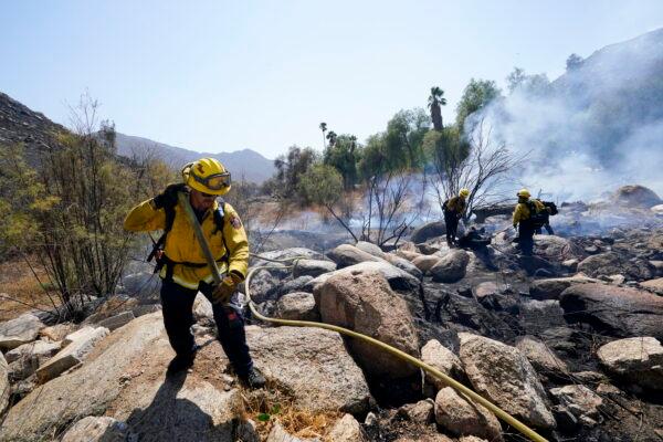 Cal Fire crews douse a flare-up near the Barrett Mobile Home and RV Park as they fight the Border Fire on Sept. 1, 2022, in Dulzura, Calif.  (AP Photo/Gregory Bull)