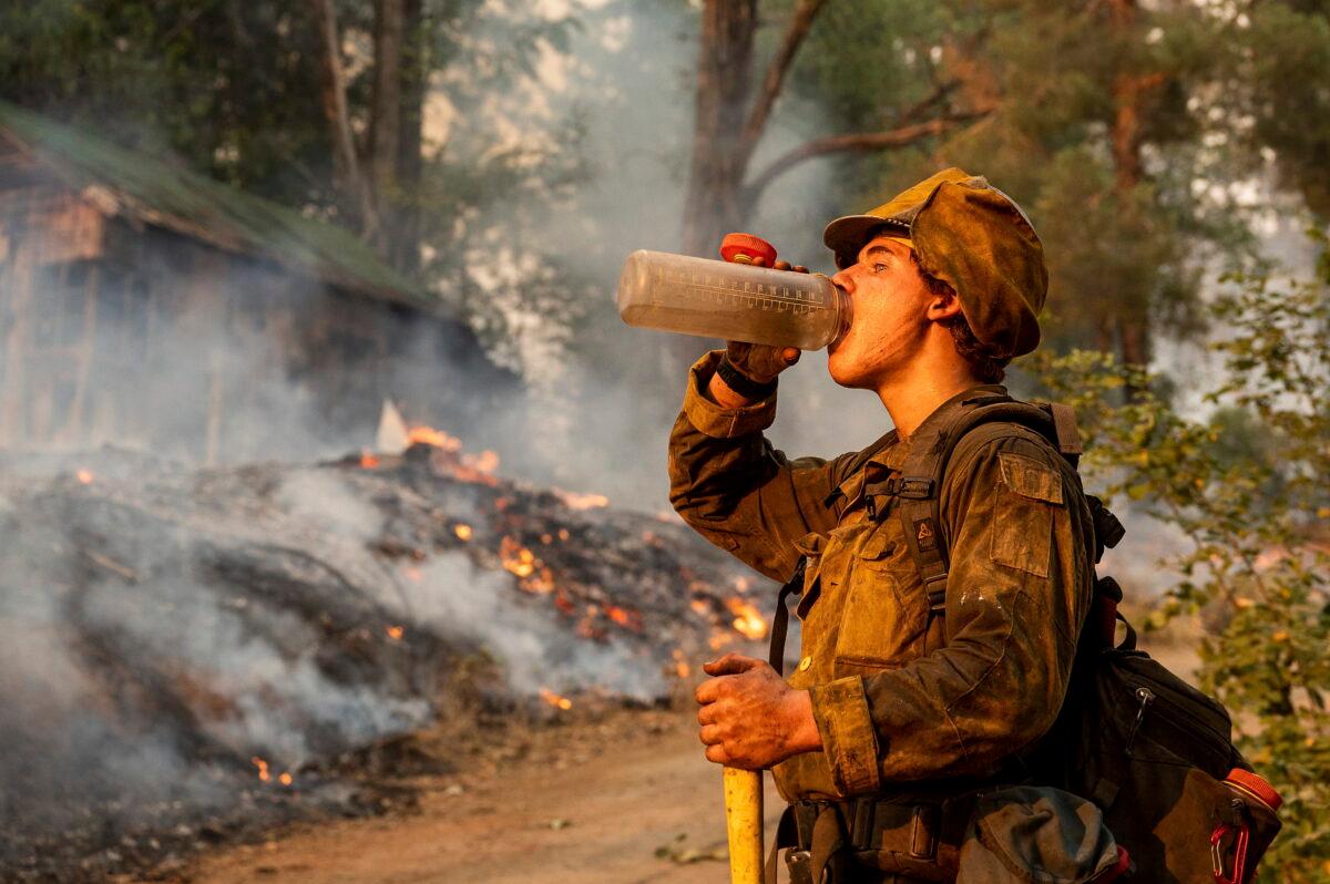 Firefighter Trapper Gephart of Alaska's Pioneer Peak Interagency Hotshot crew takes a drink while battling the Mosquito Fire in the Volcanoville community of El Dorado County, Calif., on Sept. 9, 2022. (Noah Berger/AP Photo)