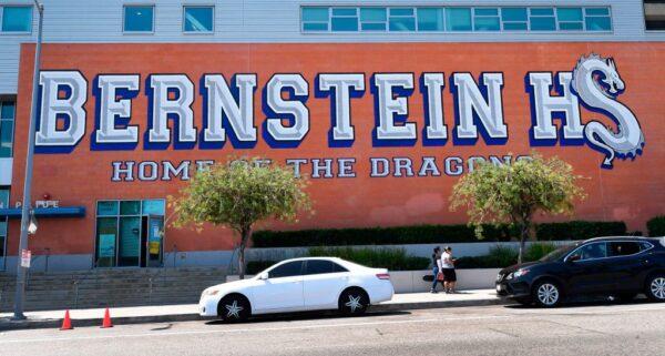A student carries her musical instrument outside Bernstein High School in Hollywood, Calif., on Sept. 3, 2020. (Frederic J. Brown/AFP via Getty Images)