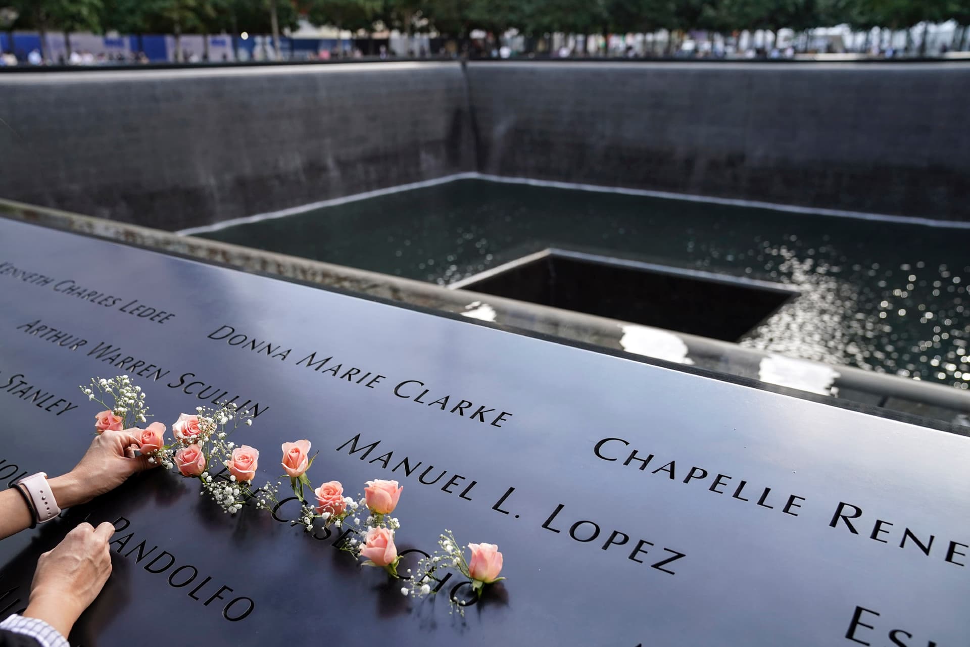 Mourners place flowers at the National September 11 Memorial and Museum in New York, Sept. 11, 2020. (AP Photo/John Minchillo)