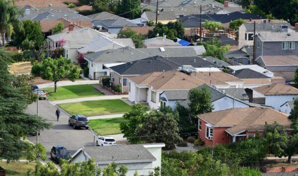 A man walks along a street in a neighborhood of single-family homes in Los Angeles on July 30, 2021. (Frederic J. Brown/AFP via Getty Images)