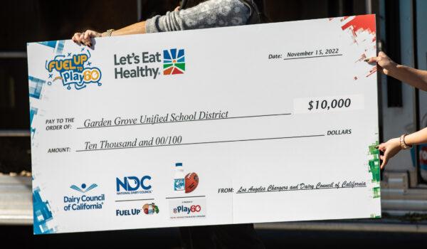 Garden Grove Unified School District officials receive a $10,000 check from the Los Angeles Chargers and Dairy Council of California at Ethel M. Evans Elementary School in Garden Grove, Calif., on Nov. 15, 2022. (John Fredricks/The Epoch Times)