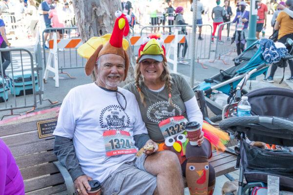 Brad and Sherry Goodrich celebrate after finishing a 5K run in the Turkey Trot in Seal Beach, Calif., on Nov. 19, 2022. (Julianne Foster/The Epoch Times)