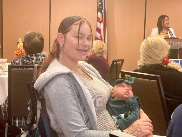 Alissa Creech holds her daughter at a West Orange County Republican Women’s Federated meeting in Cypress, Calif., on Nov. 19, 2022. (Carol Cassis/The Epoch Times)
