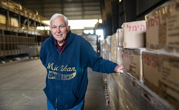 Mayor of Stanton Calif., Dave Shawver stands next to boxes of hand sanitizer and cooling bags to be handed out to low-income families in Stanton, Calif. on Nov. 21, 2022. (John Fredricks/The Epoch Times)