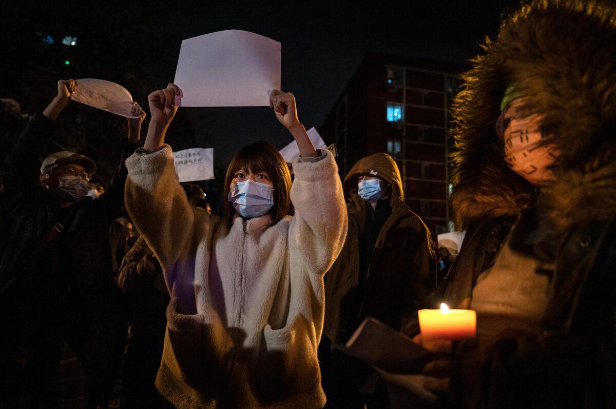 Protesters hold up a white piece of paper against censorship as they march during a protest against China's strict zero-COVID policy in Beijing on Nov. 27, 2022. (Kevin Frayer/Getty Images)