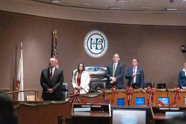 (L–R) The four new councilors—Pat Burns, Mayor Pro Tem Gracey Van Der Mark, Mayor Tony Strickland, and Casey McKeon—stand and sing “Proud to Be an American” with the rest of the public during the ceremony’s musical dedication in Huntington Beach, Calif., on Dec. 6, 2022. (Julianne Foster/The Epoch Times)