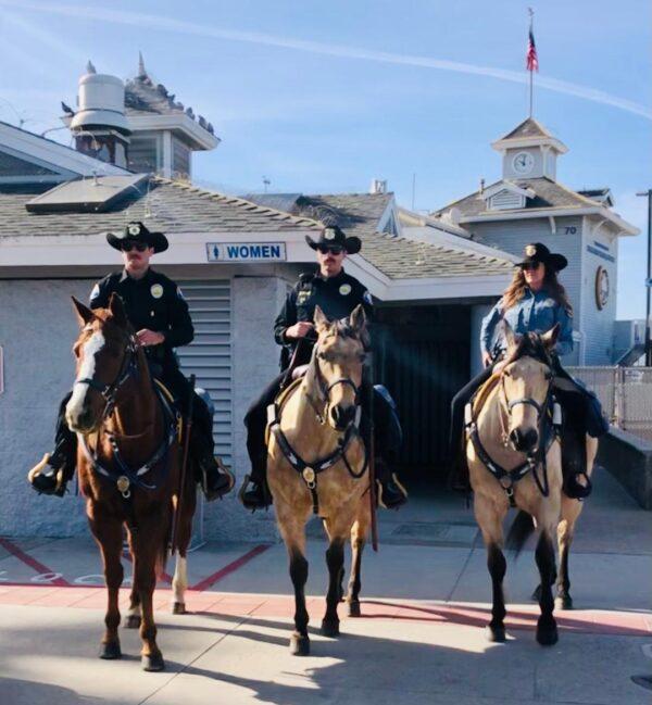 Newport Beach Police Department officers ride horses at Mobile Café in Newport Beach, Calif., on Feb. 4, 2023. (L-R) Officer Isaac Furnari and "Bullseye," Officer Nathan Farris on "Buckie," and civilian volunteer Lori Hayden on "Huck." (Lynn Hackman/The Epoch Times)