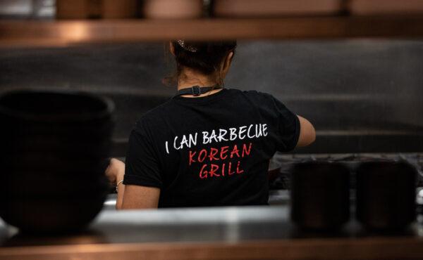 A cook prepares food at I Can Korean Barbecue in Tustin, Calif., on Feb. 14, 2023. (John Fredricks/The Epoch Times)