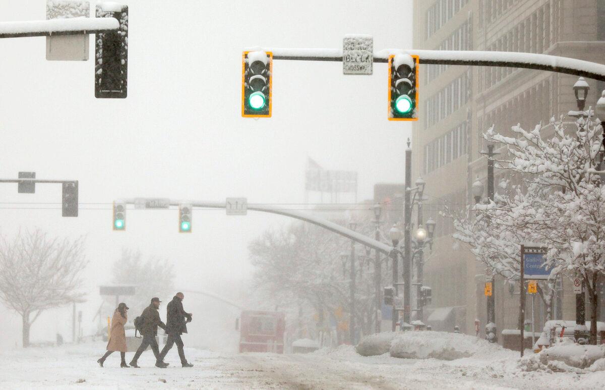 People cross a street during a snowstorm in Salt Lake City, Utah, on Feb. 22, 2023. (Kristin Murphy/The Deseret News via AP)